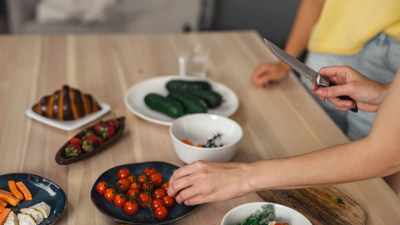 Hands preparing vegetables at a kitchen table