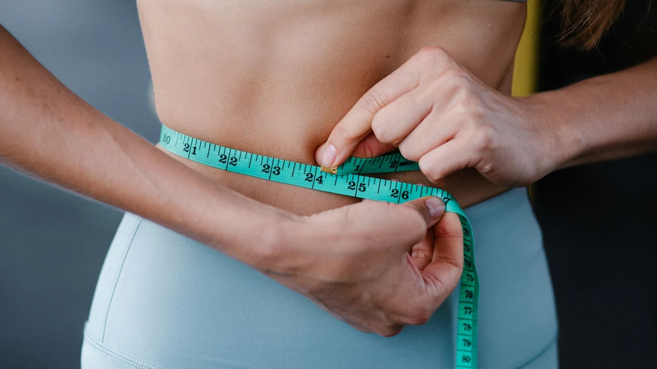 Person holding a tape measure around the waist
