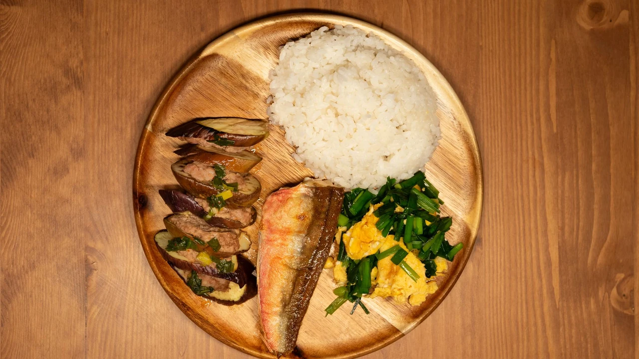 Fish, rice and vegetables arranged on a wooden plate