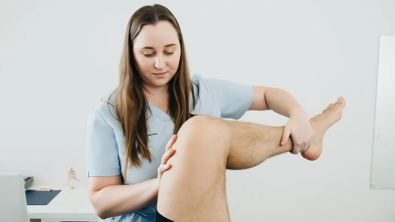A physiotherapist working with a person’s knee.