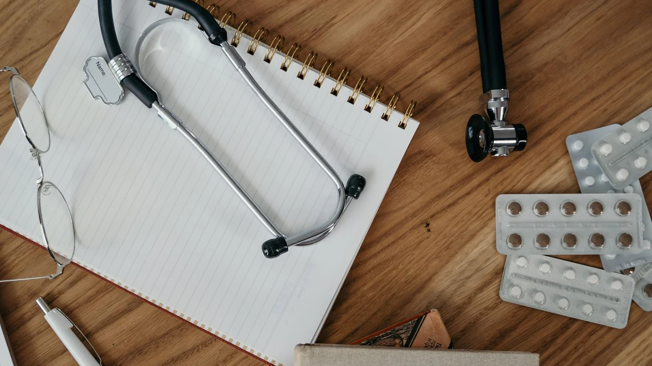 A notebook and stethoscope prepared for a health appointment.