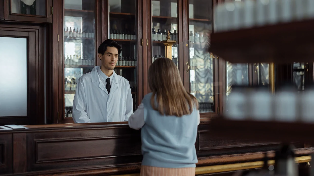 A pharmacist discussing products at a pharmacy counter.