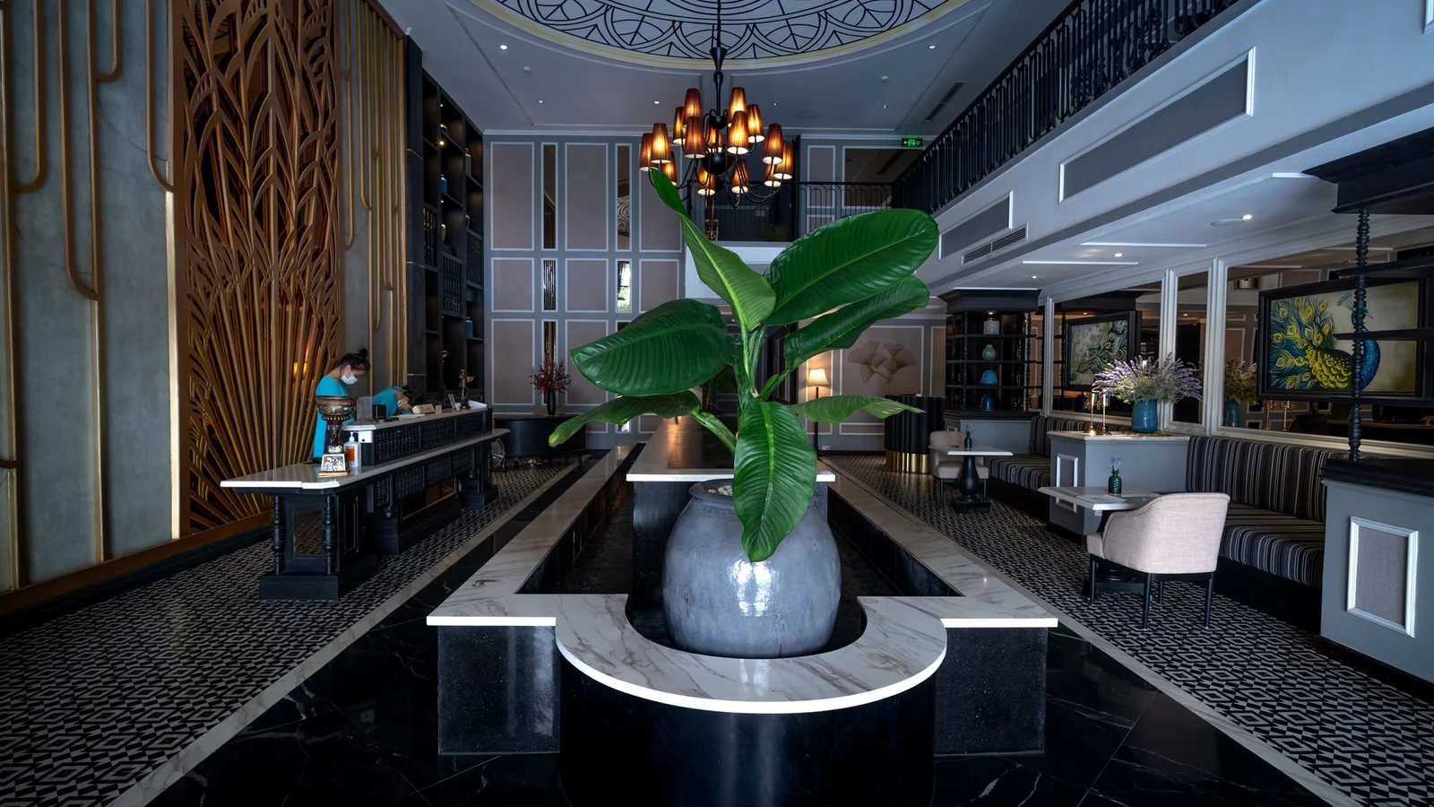 Illustrative hotel reception with a central plant arrangement and a seating area.