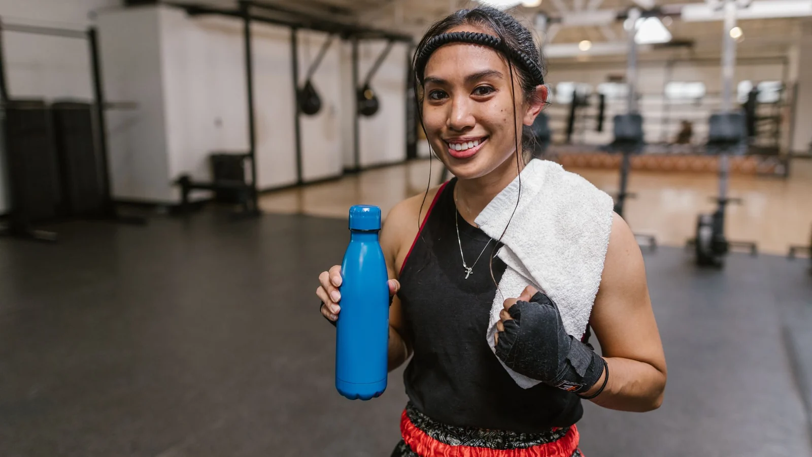 A gym towel and water bottle held after a workout.