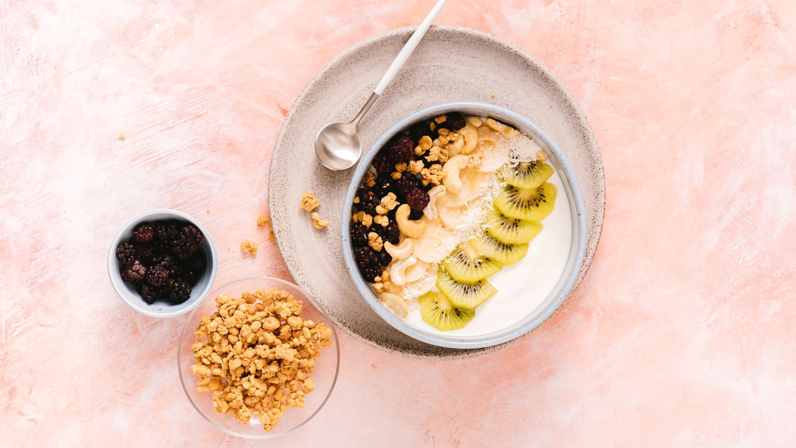 A bowl of yogurt with fruit and nuts.