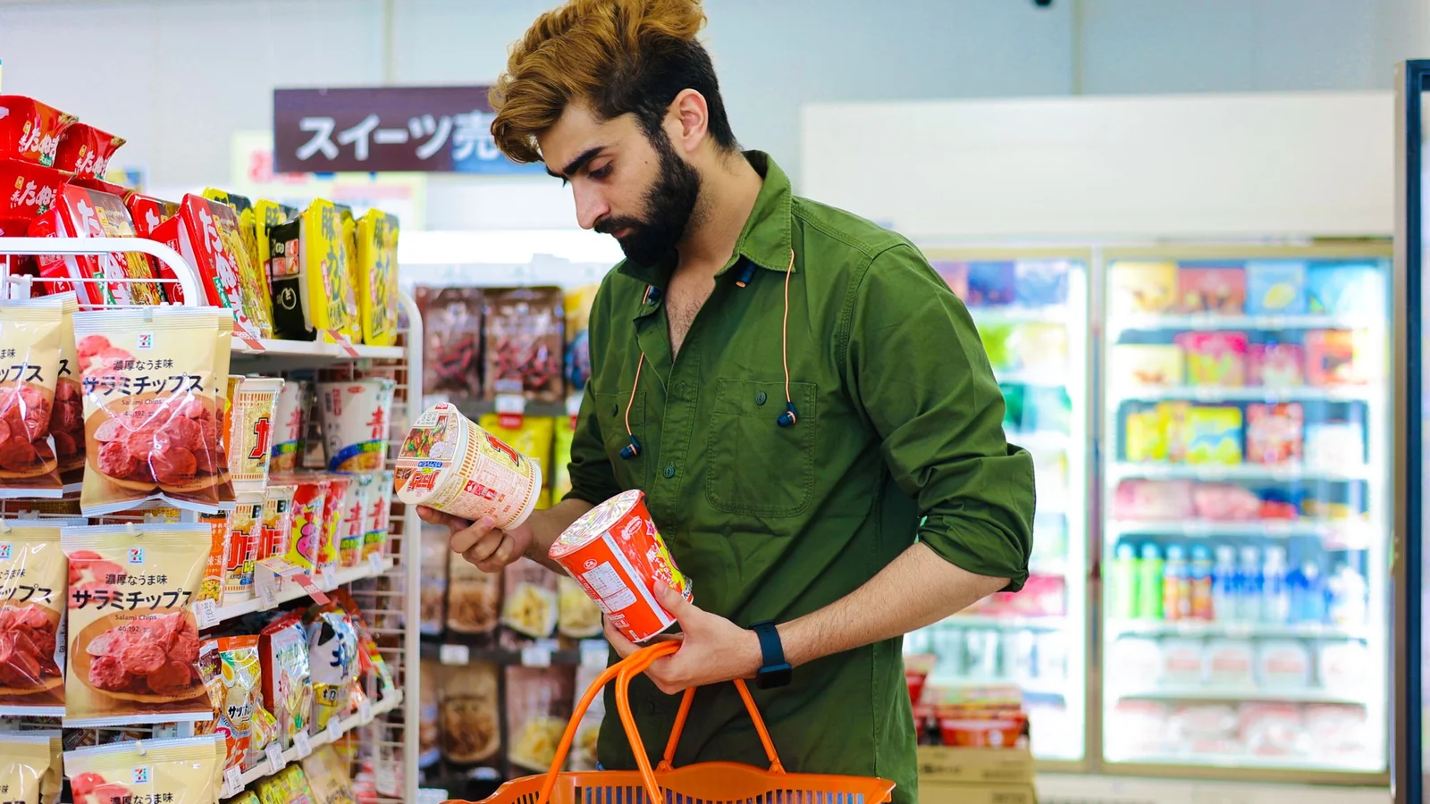 A shopper reading a packaged food label in a shop.