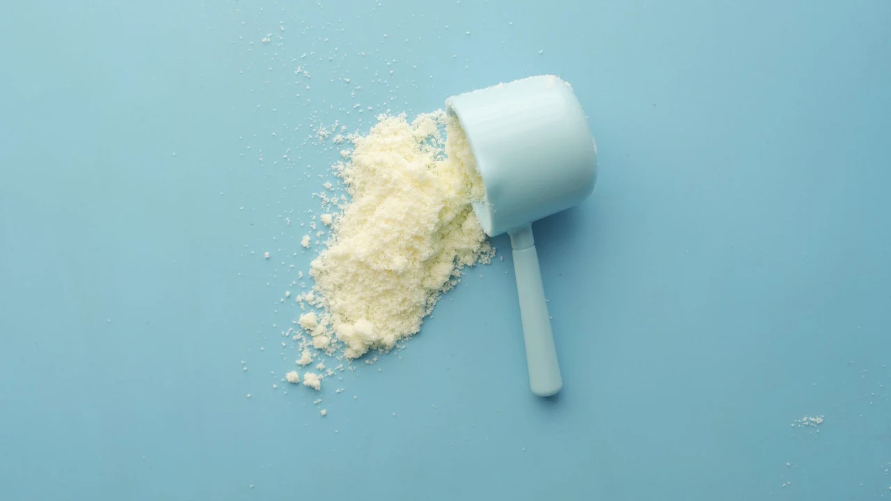 Pale powder spilling from a measuring scoop