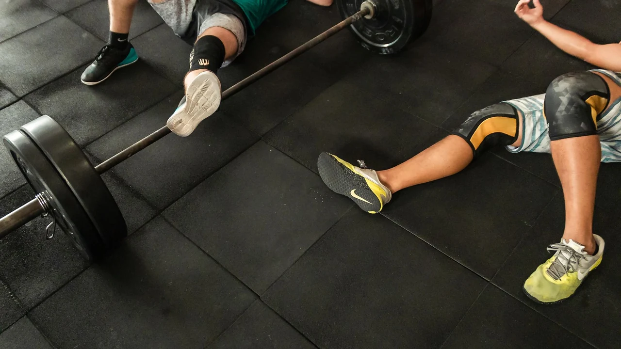People exercising near a barbell on the floor