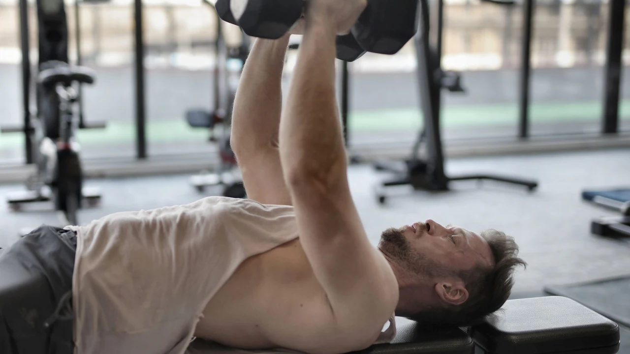 Man lifting dumbbells while lying on a bench