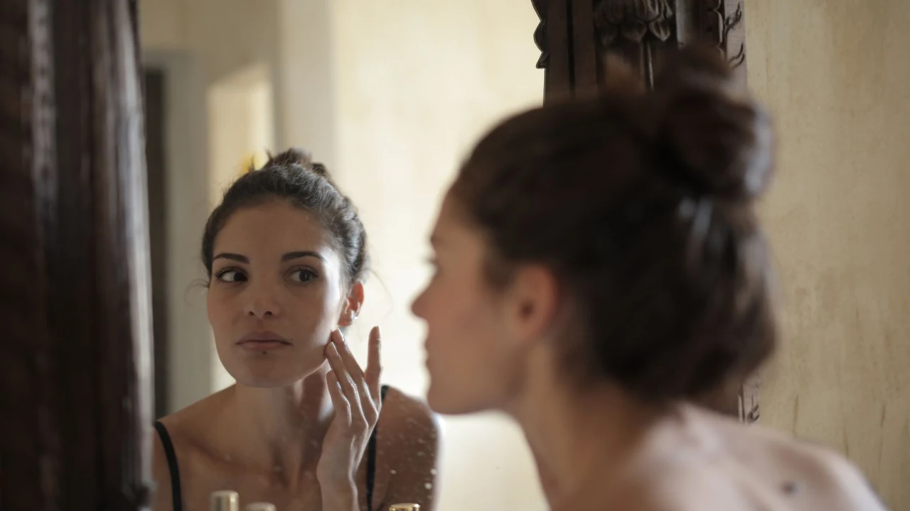 Woman looking at her face in a mirror