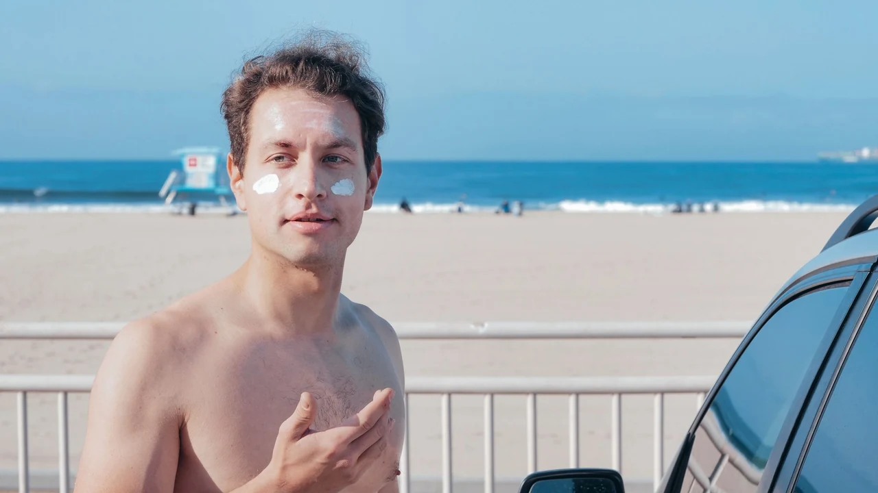 Man at the beach with white cream on his face