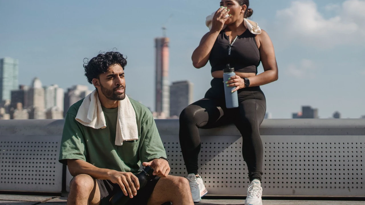 Two adults resting outdoors with water bottles.