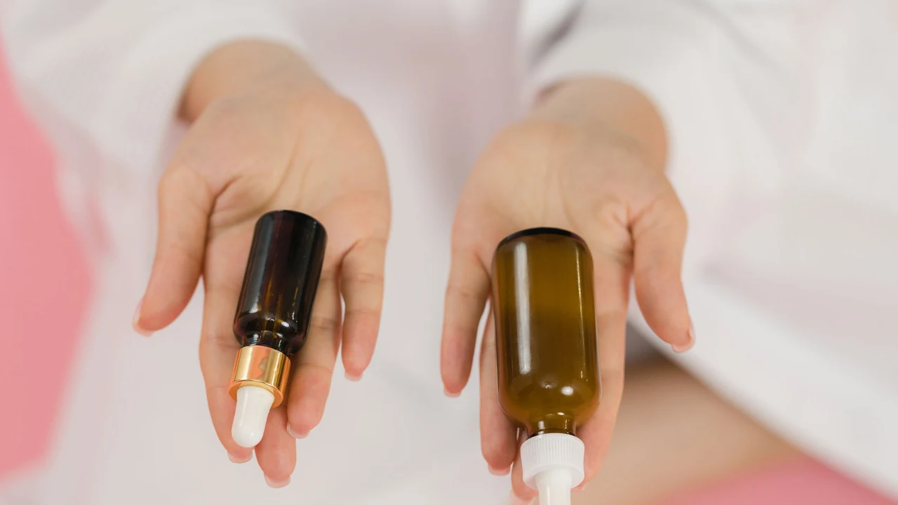 Hands holding two cosmetic bottles.