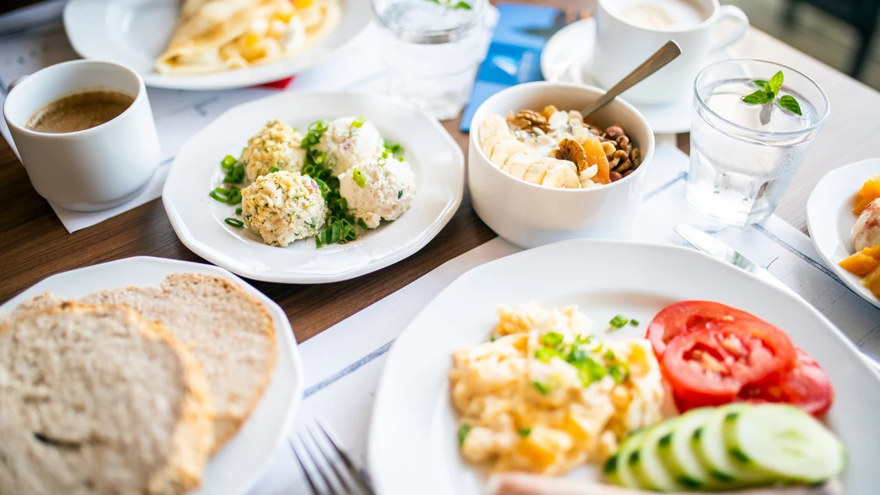 Breakfast table with eggs, bread and vegetables.