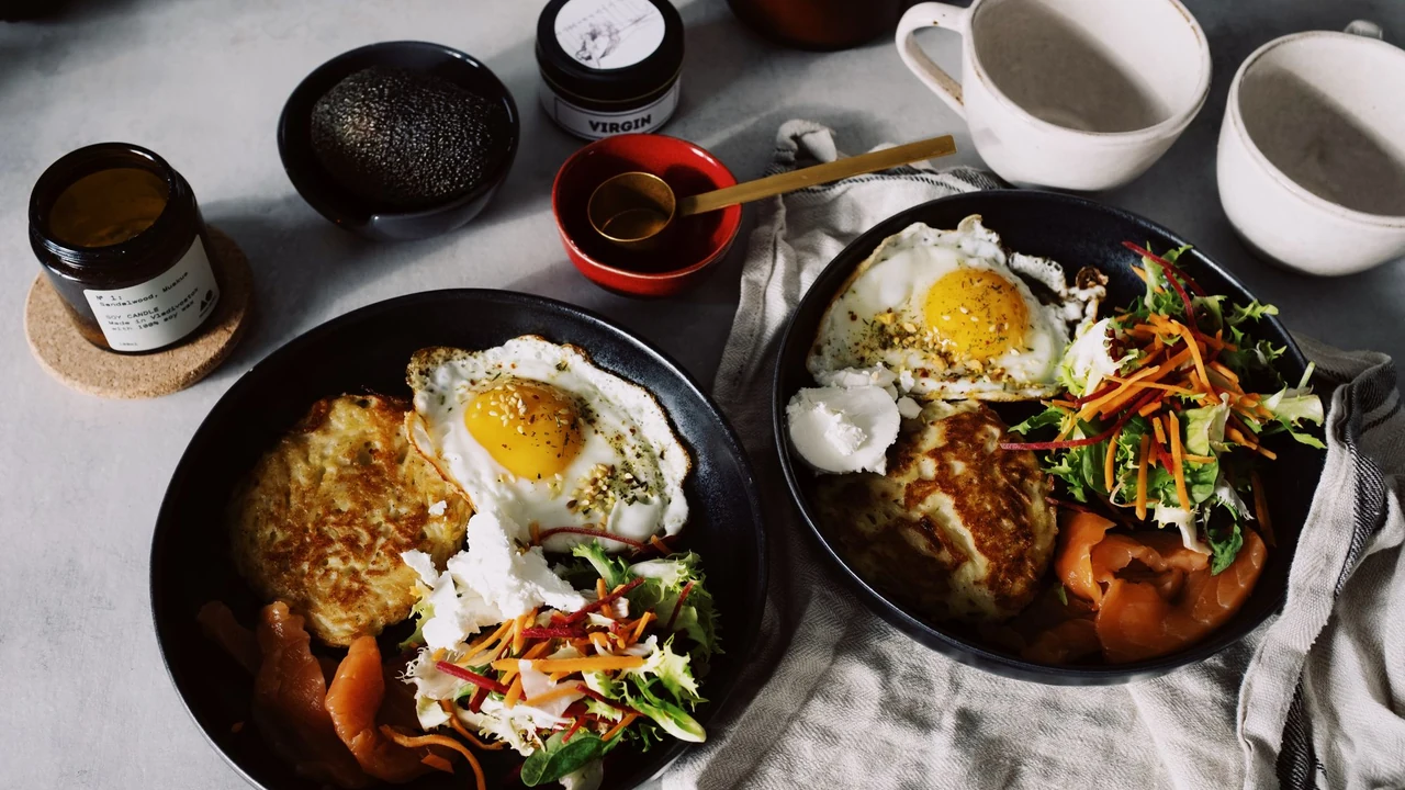 Two bowls of rice, vegetables and fried eggs.