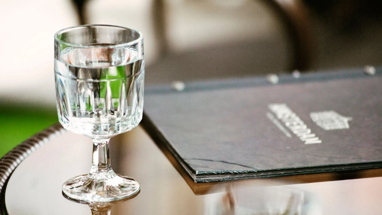 Water glass beside a menu.