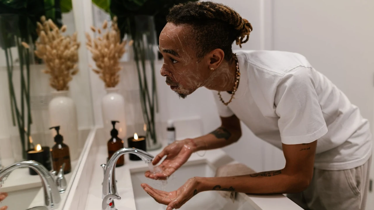 A man washing his face at a bathroom sink