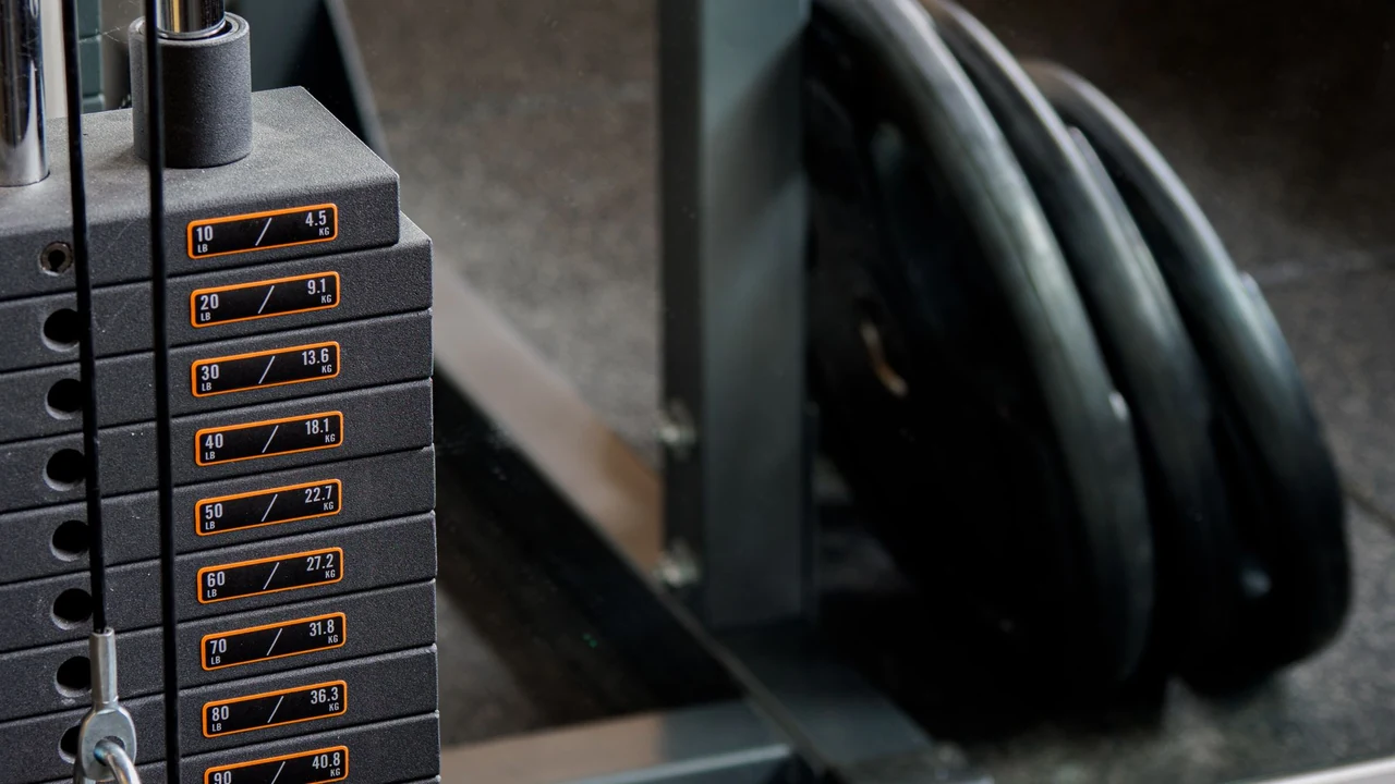 A numbered weight stack and plates in a gym